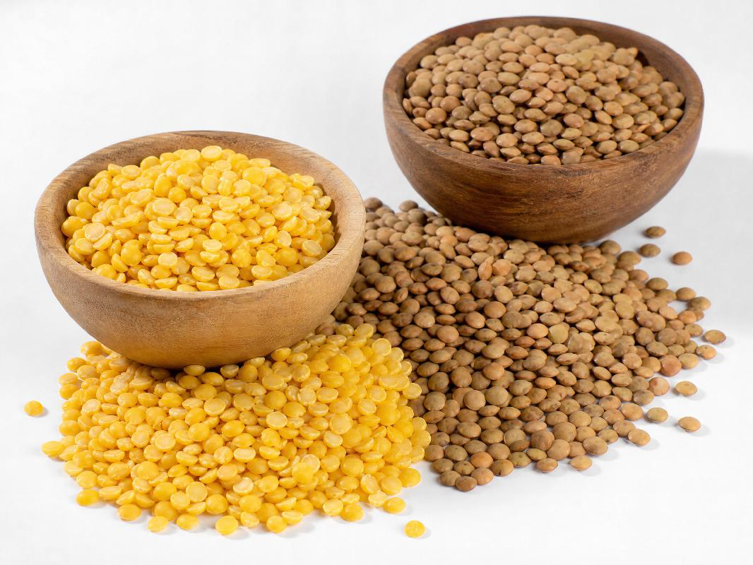 Yellow lentils and brown lentils in wooden bowls